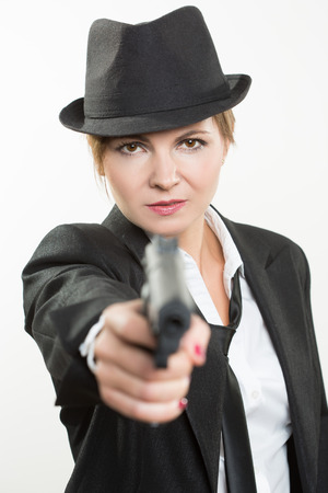 beautiful girl gangster holding a gun. Classic suit and hatの写真素材