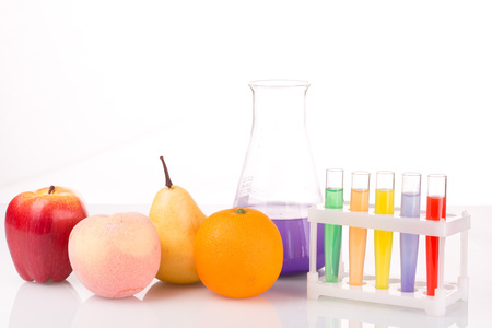 Fruit close chemical test tubes. Genetic Engineering. pesticides in foods. White background.の写真素材