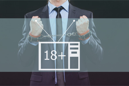 man in a business suit with chained hands.