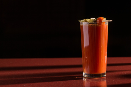photo of delicious tomato bloody mary cocktail on reflecting glass table with spot lightの写真素材