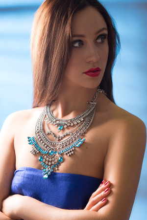 necklace on the neck. colored gems. blue backgroundの写真素材