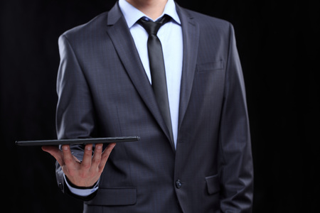 smiling businessman in business suit with tablet.の写真素材