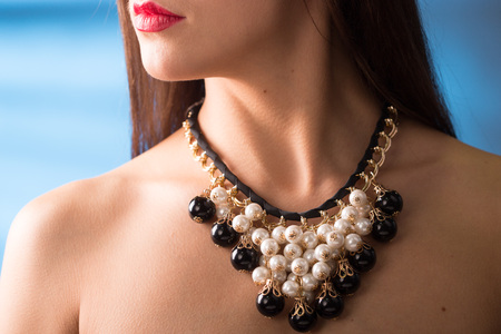 necklace on the neck. colored gems. blue backgroundの写真素材