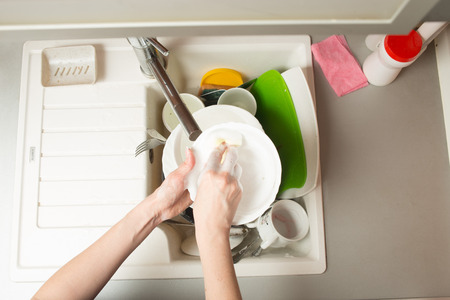 close up hands of Woman Washing Dishes in the kitchenの写真素材