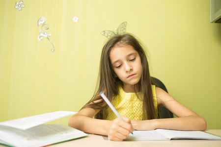 clever girl doing homework in his room. at the deskの写真素材