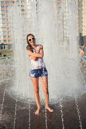 Attractive girl bathing in city fountain. hot weatherの写真素材