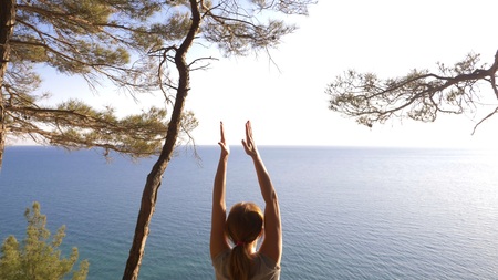 Woman fitness runner on top happy and celebrating success. the woman enjoys the view of the sea from...