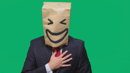 concept of emotions, gestures. a man with paper bags on his head, with a painted emoticon, smile,...