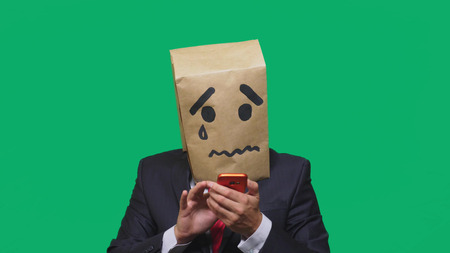 concept of emotion, gestures. a man with a package on his head, with a painted smiley crying, sad,...