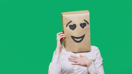 concept of emotions, gestures. a man with paper bags on his head, with a painted emoticon, smile,...