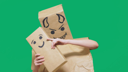 concept of emotions, gestures. a man with a package on his head, with a painted emoticon devil,...