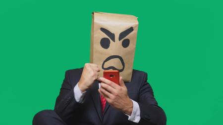 concept of emotion, gestures. a man with a package on his head, with a painted smiley aggressive, angryの写真素材