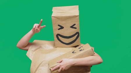concept of emotions, gestures. man with a package on his head, with a painted emoticon, smile, joy, laughter. plays with the child painted on the boxの写真素材