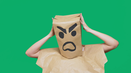 concept of emotion, gestures. a man with a package on his head, with a painted smiley aggressive, angryの写真素材