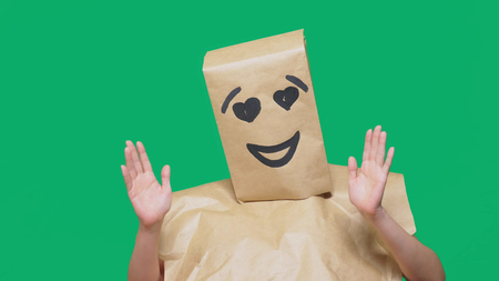 concept of emotions, gestures. a man with paper bags on his head, with a painted emoticon, smile, joy, love eyesの写真素材
