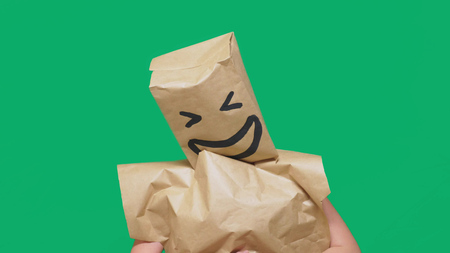 concept of emotions, gestures. a man with paper bags on his head, with a painted emoticon, smile,...