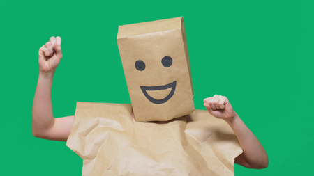 concept of emotions, gestures. a man with paper bags on his head, with a painted emoticon, smile, joy.の写真素材