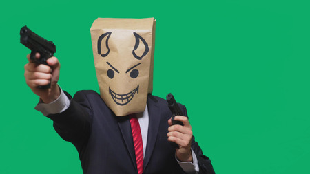 concept of emotion, gestures. a man with a package on his head, with a painted smiley angry, sly, gloating, devil.の写真素材