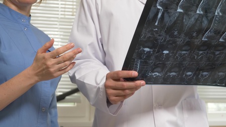 doctors, a man and a woman analyze the results of MRI x-ray images. the results of magnetic...
