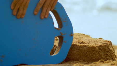 girl builds a sand castle on a tropical beach. close-up.の写真素材
