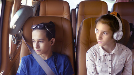 concept of summer vacation, travel. teenagers boy and girl ride in a minivan with headphones.の写真素材