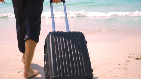 businessman with a suitcase goes on a white sandy beach. concept of freelancing, vacationの写真素材