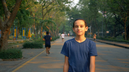 Portrait of a teenager walking with pleasure in nature in a large parkの写真素材