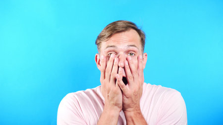 Young man on color blue background. portrait. emotions and gestures. close-up. surprise.の写真素材