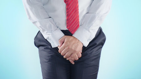 a person has problems with the genitourinary system. businessman on a colored background. close-upの写真素材