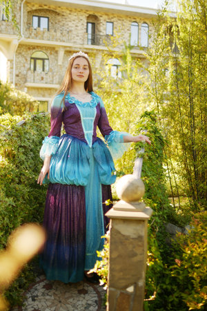 girl animator dressed as a medieval princess on the background of the castle in a beautiful parkの写真素材