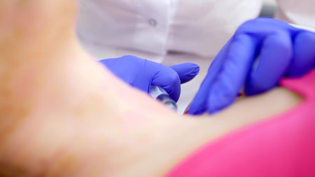 The cosmetologist makes injections, anti-aging procedures for tightening and smoothing wrinkles on the skin of the face and neck of a woman.の写真素材