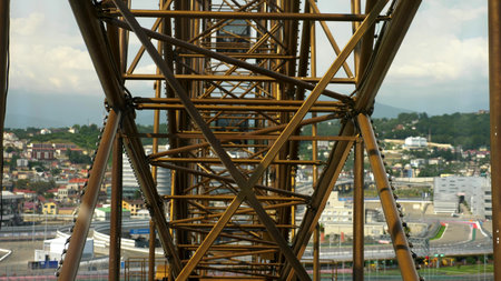 Metallic Mechanism of the Ferris wheel from the cabin, against the background of the city