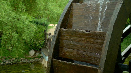 water Mill. close-up. the details. the wooden wheel of the mill rotates under the stream of water