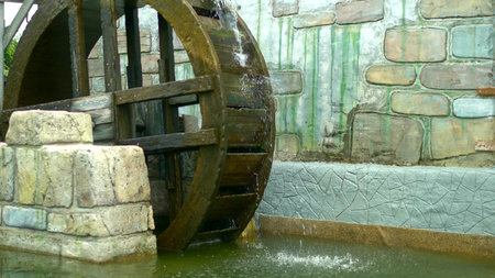water Mill. close-up. the details. the wooden wheel of the mill rotates under the stream of water