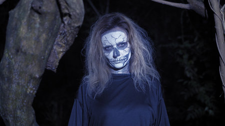 concept of horror, ghost woman in the forest. Beautiful woman with make-up skeleton in a scary...