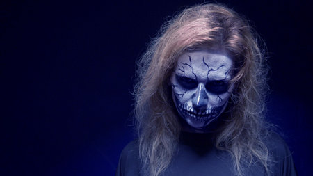 concept, beautiful makeup for halloween. Portrait of a young sexy girl with skull makeup. on a black...