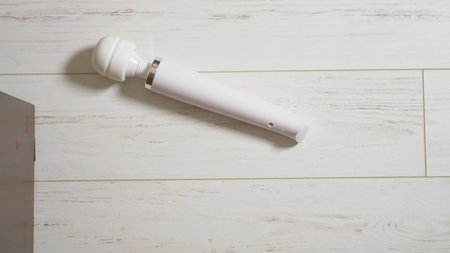 White female vibrator on a white wooden floor, turns on and moves on the floor.の写真素材