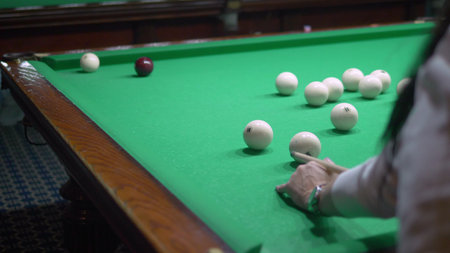 billiards. Close-up. man hand with cue and white ball on a green pool table. copy space.