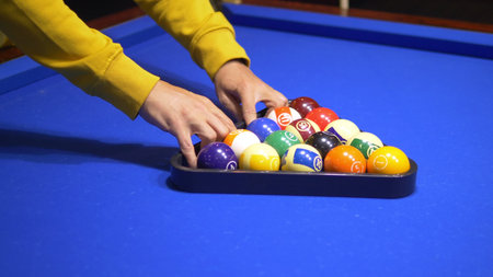 fashionable guy puts on a pool table A full set of billiards in a triangular frame on a green...