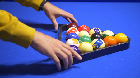 fashionable guy puts on a pool table A full set of billiards in a triangular frame on a green...