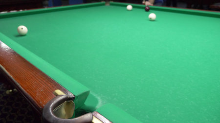 billiards. Close-up. man hand with cue and white ball on a green pool table. copy space.