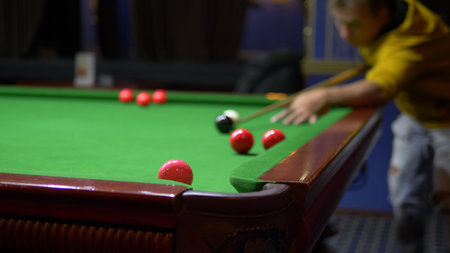 young man, professional billiard player playing american billiards