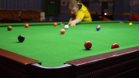 young man, professional billiard player playing american billiards