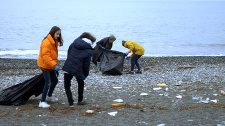 volunteers clean up trash on the beach in the fall. environmental issuesの写真素材