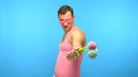 handsome man freak in pink glasses with a bouquet of flowers. blue backgroundの写真素材