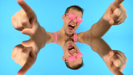 Funky stylish handsome guy in pink sunglasses. man freak screaming.の写真素材
