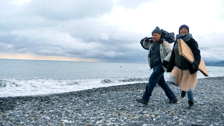 happy homeless couple, a man and a woman running on the beachの写真素材