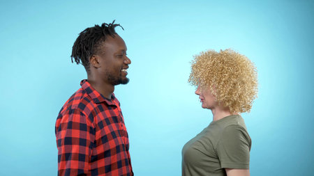African man and Caucasian woman with Afro hairstyle. blue background
