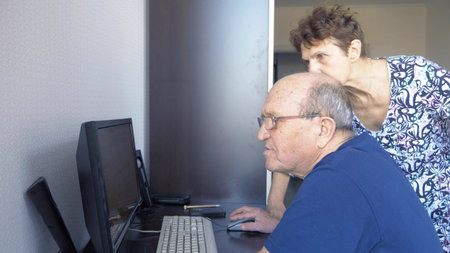 elderly couple man and woman using computer together