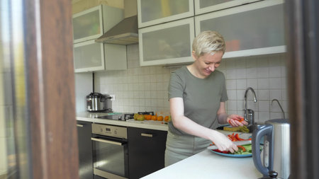 woman cuts vegetables for a snack in the kitchen at home